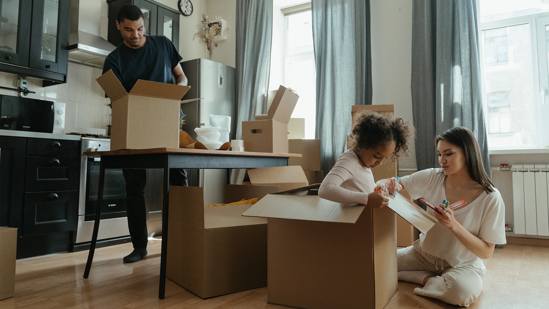 family unpacking boxes to move in